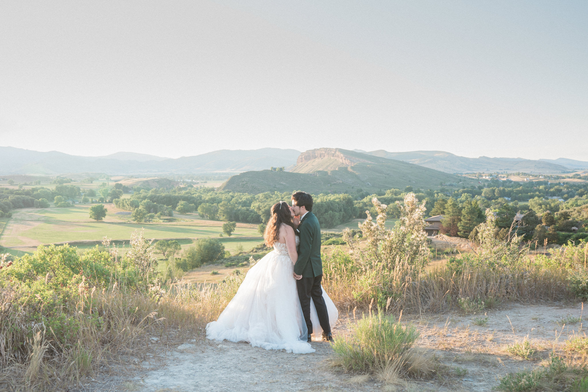 A couple kiss in front of a gorgeous mountain scene for their Colorado elopement photographer.