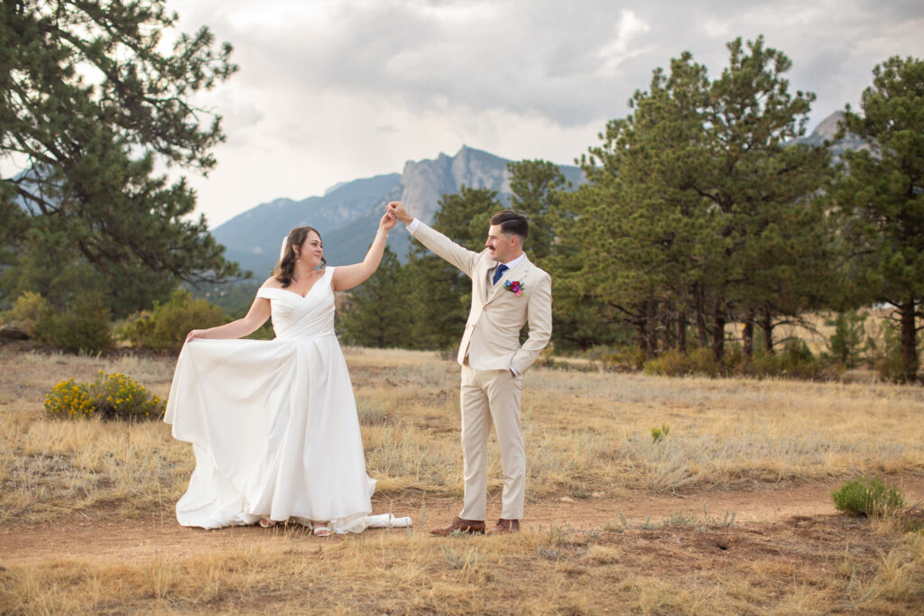 A man twirls his bride during their elopement at Knoll Willows Open Space in Estes Park.