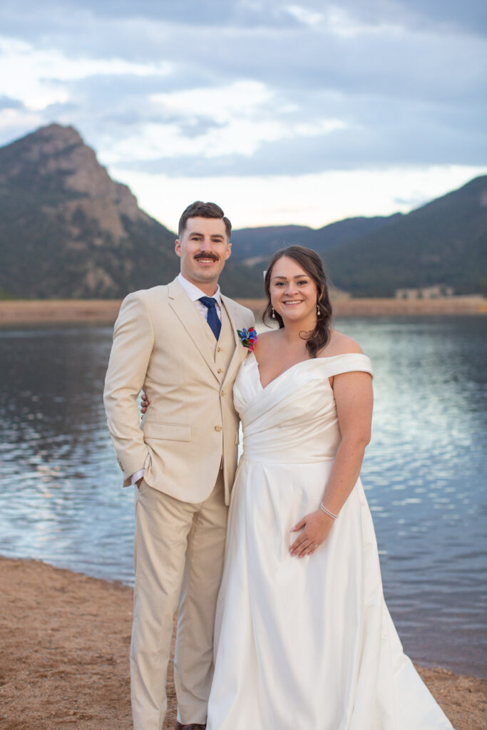 An eloping couple smile for the camera at Lake Estes