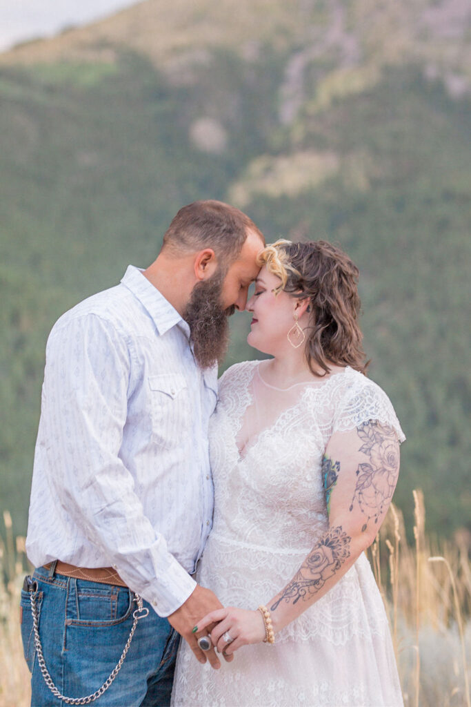 Newlyweds snuggle noses and hold hands in the mountains at one of the Fort Collins Wedding Venues