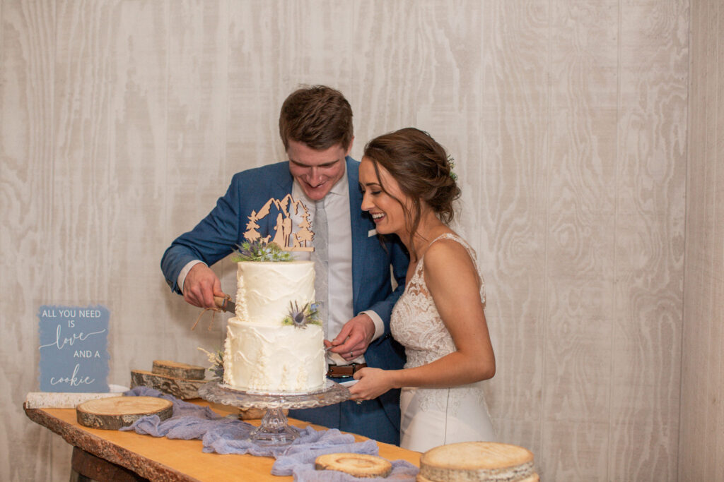 A bride and groom cut their cake during their Colorado wedding