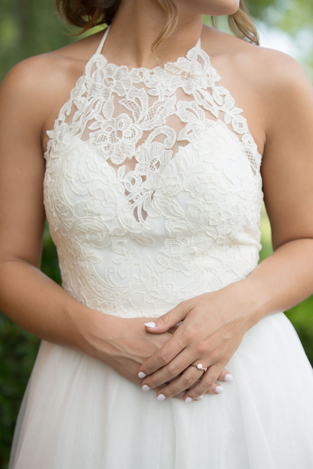 Details of a bride's lace covered chest with hands crossed