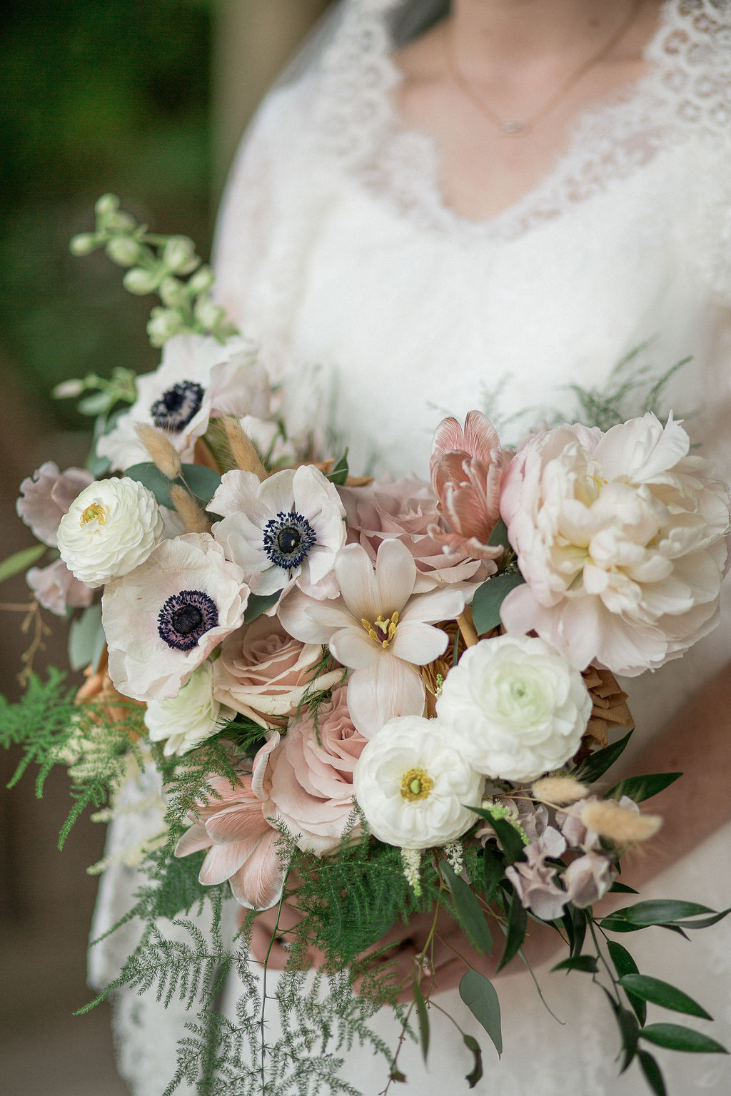 Details of a bride's bouquet in her hands with white and pink flowers at the mill event venue