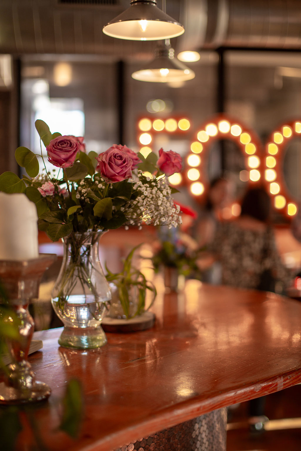 Details of a bouquet in a vase on the bar counter at the riverside wedding venue