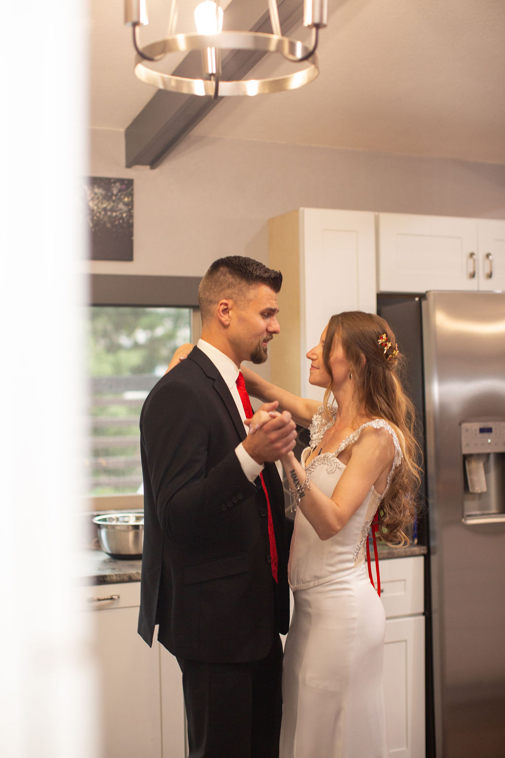 Newlyweds dance in a kitchen smiling at each other thanks to support from colorado elopement planners