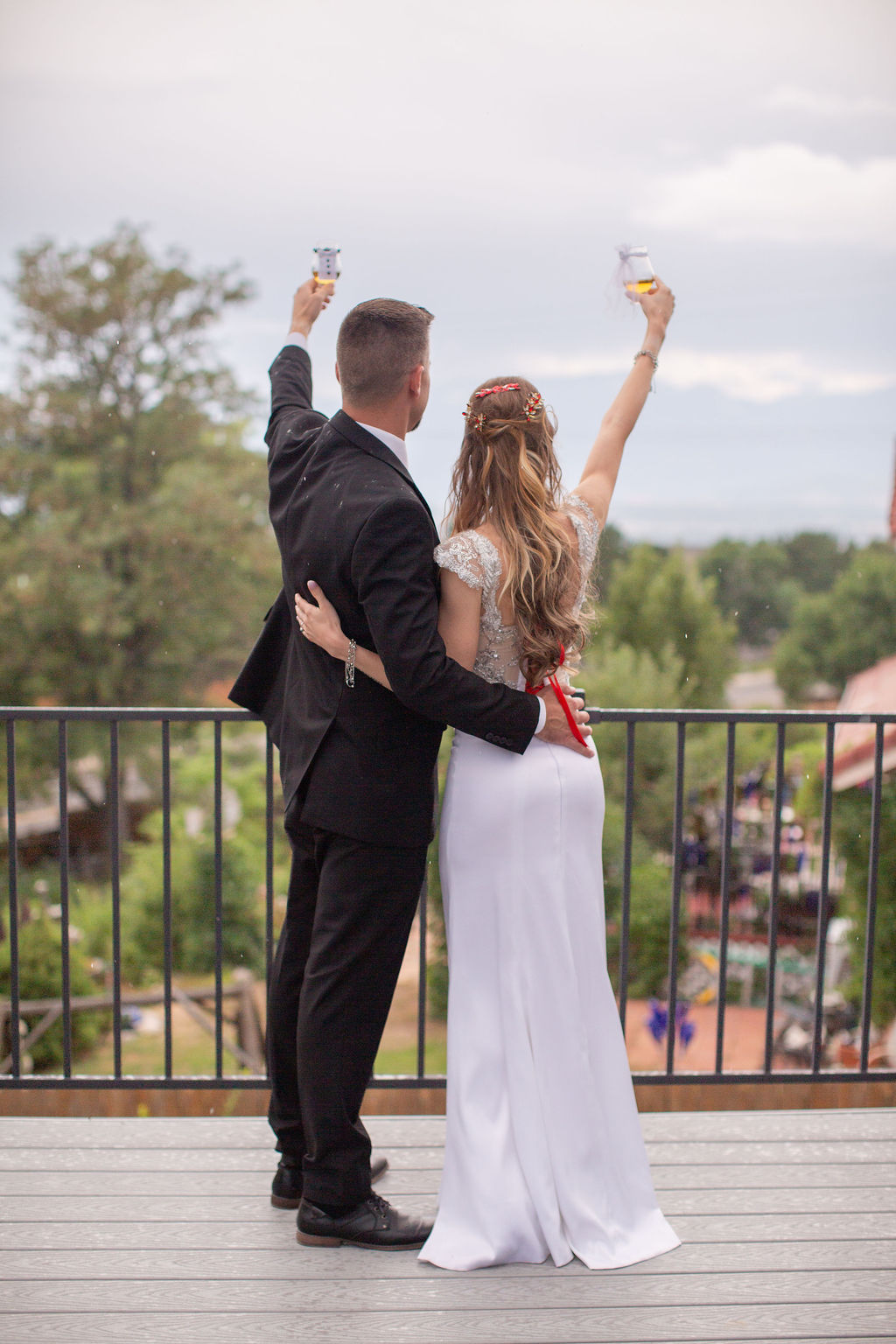Newlyweds toast champagne from a balcony overlooking their guests at one of the micro-wedding venues in colorado