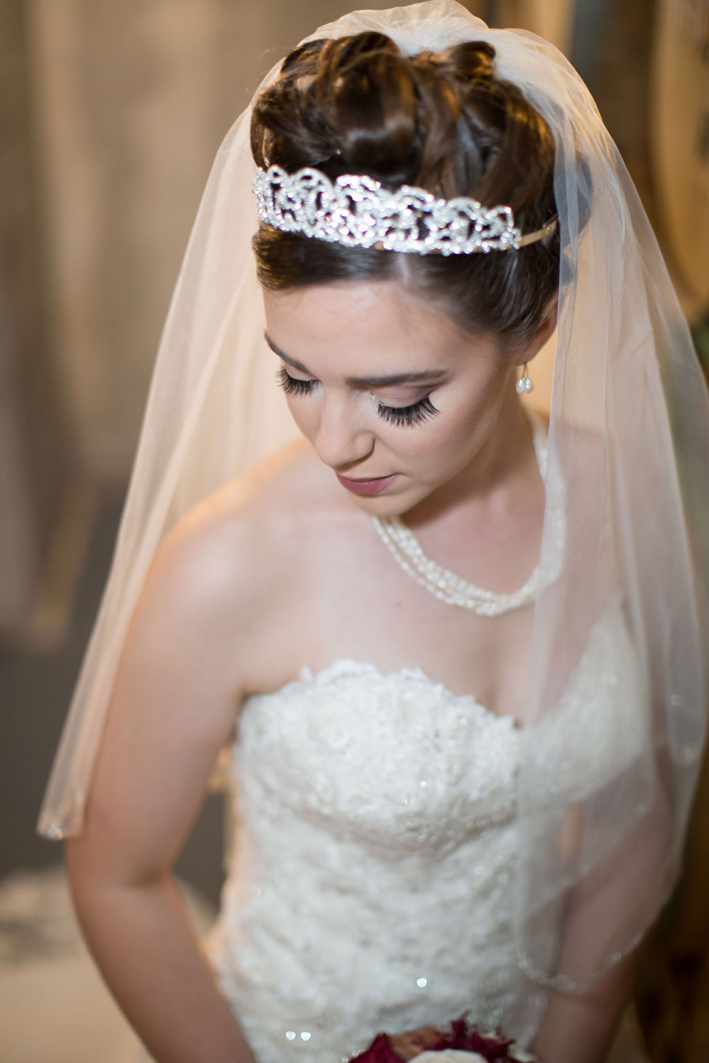 A bride glances down her shoulder while standing with her short veil and diamond tiara at one of the small wedding venues in estes park