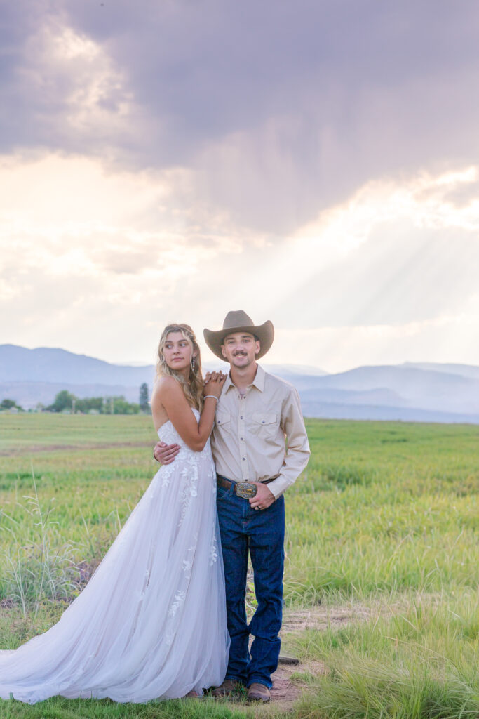 Newlyweds sharing a tender moment near a mountain overlook in Rocky Mountain National Park.