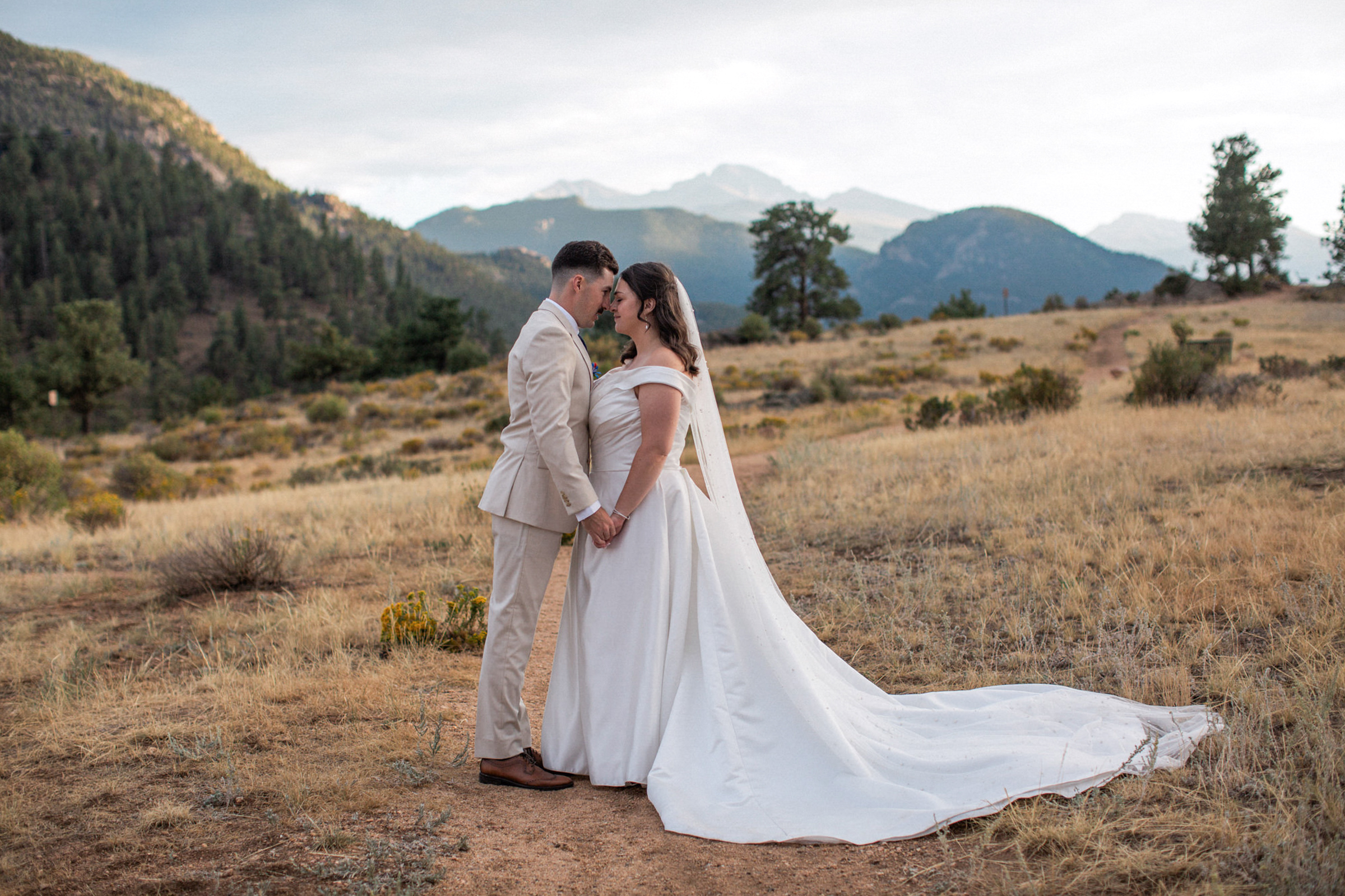 Romantic eloping couple embracing in the mountains of Rocky Mountain National Park with their elopement photographer